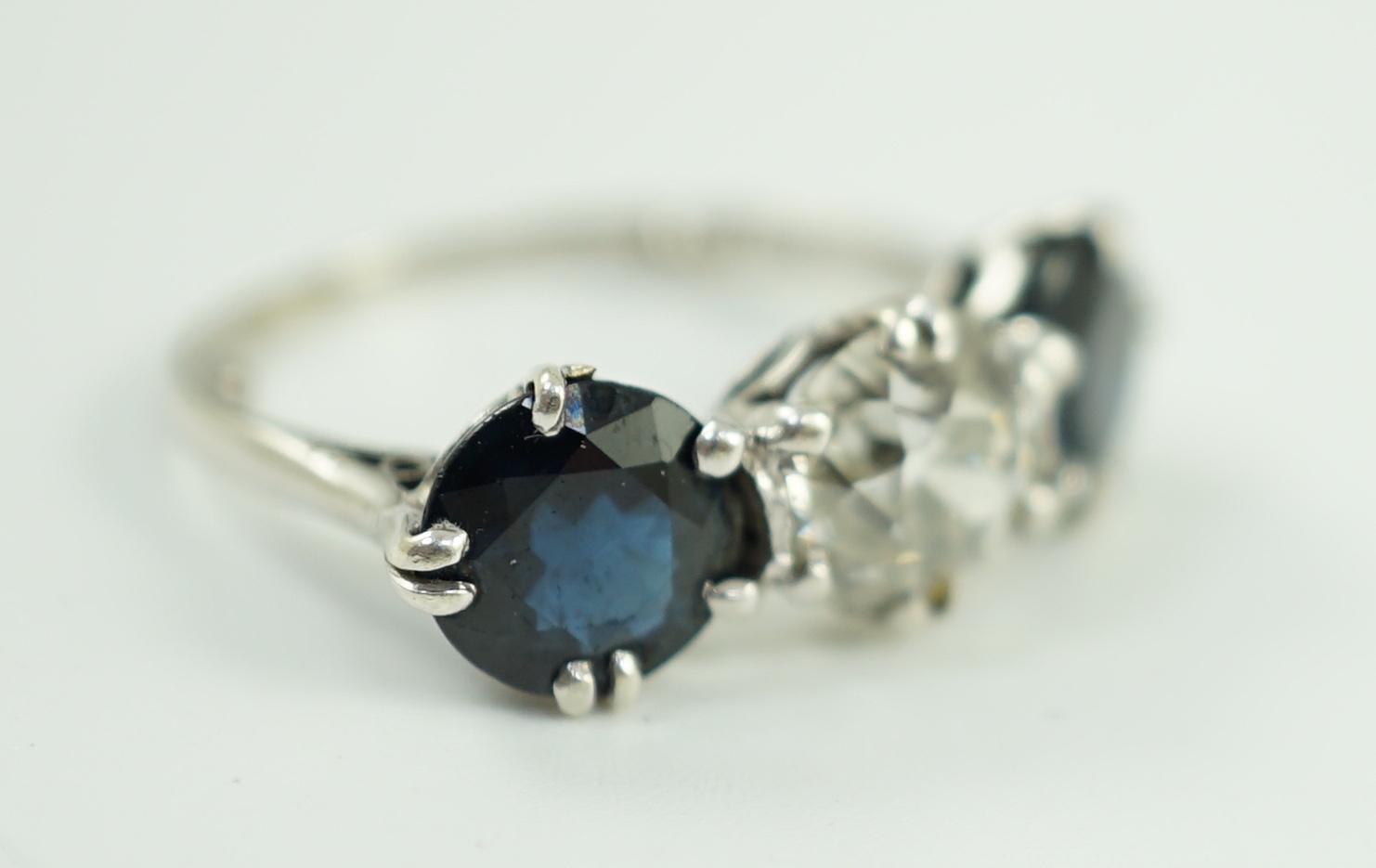 A white gold, sapphire and diamond set three stone ring, central stone approximately 1.4ct